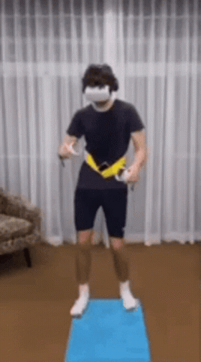 A Man Wearing A Virtual Reality Headset Is Standing On A Blue Mat In A Living Room . GIF
