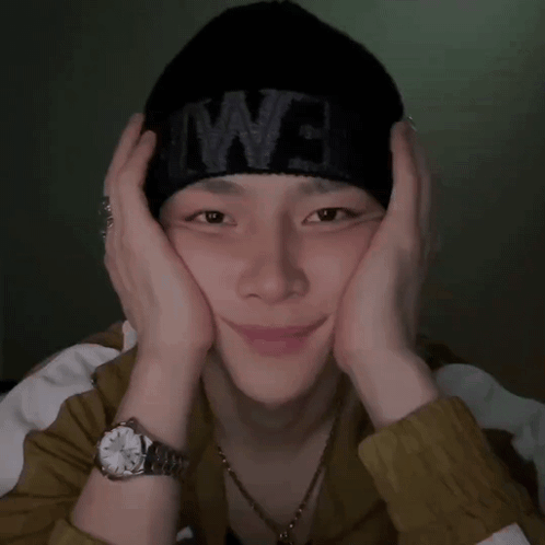 A Man Wearing A Watch And A Black Beanie With The Word We On It GIF