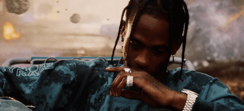 A Man Wearing A Watch And A Ring Is Wearing A Shirt That Says Travis Scott GIF
