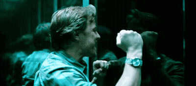 A Man Wearing A Watch Holds His Fist Up In Front Of A Mirror . GIF