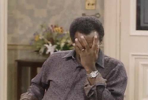 A Man Wearing A Watch Is Covering His Face With His Hand GIF