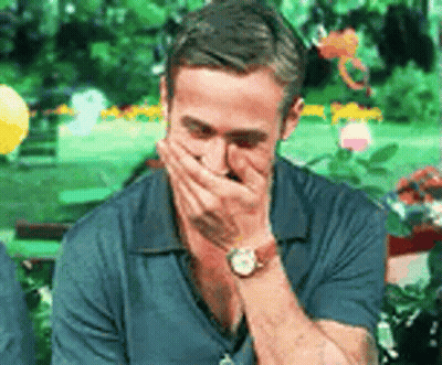 A Man Wearing A Watch Is Covering His Mouth With His Hands . GIF