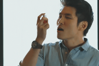 A Man Wearing A Watch Is Spraying Something In His Hand GIF