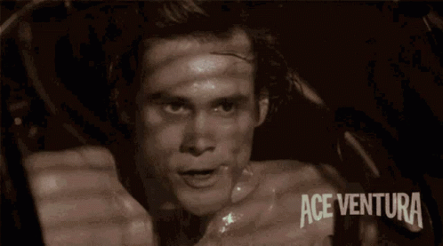 A Man Wearing A Watch With Ace Ventura Written On The Bottom Right GIF