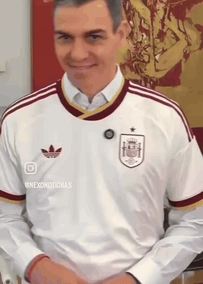 A Man Wearing A White Adidas Shirt Is Smiling And Looking Down GIF