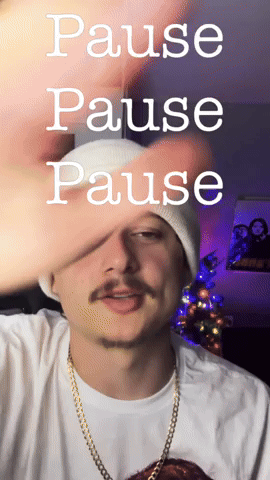 A Man Wearing A White Beanie And A Gold Chain Says Pause GIF