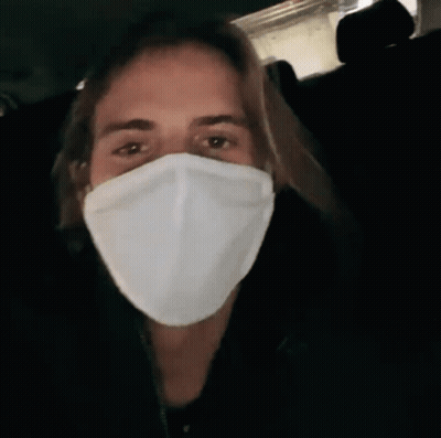 A Man Wearing A White Face Mask In A Dark Room GIF