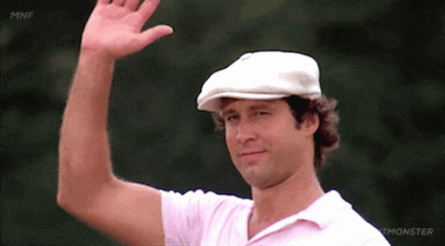 A Man Wearing A White Hat And A Pink Shirt Waves GIF