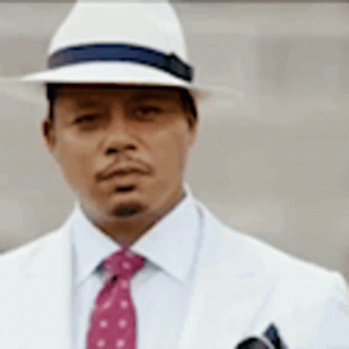 A Man Wearing A White Hat And A Red Tie Is Standing In Front Of A Wall . GIF