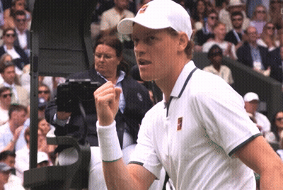 A Man Wearing A White Hat And A White Shirt Holds His Fist Up GIF