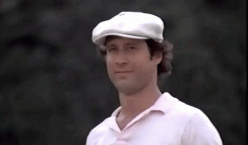 A Man Wearing A White Hat And A White Shirt Is Holding A Golf Ball In His Hand GIF