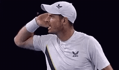 A Man Wearing A White Hat And A White Shirt Is Holding His Hand To His Face . GIF