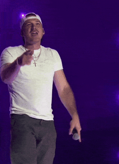 A Man Wearing A White Hat And A White T-Shirt Holds A Microphone GIF
