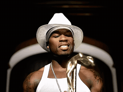 A Man Wearing A White Hat And A White Tank Top Holds A Gold Statue GIF