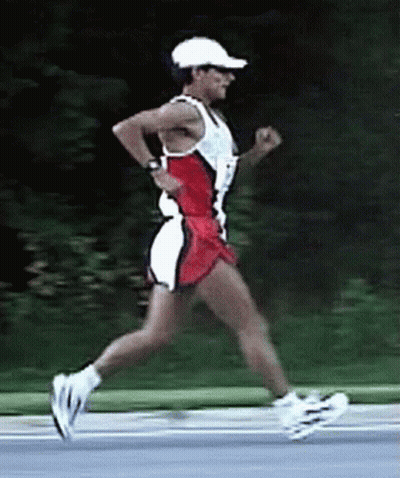 A Man Wearing A White Hat And Sunglasses Is Running On A Road GIF
