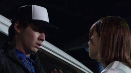 A Man Wearing A White Hat Is Touching Another Man 'S Face GIF