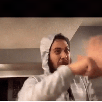 A Man Wearing A White Hoodie Is Making A Funny Face While Talking On A Video Call . GIF