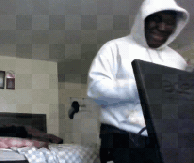 A Man Wearing A White Hoodie Is Standing In Front Of An Acer Laptop GIF