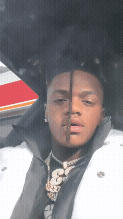 A Man Wearing A White Jacket And A Black Shirt With The Number 33 On It GIF