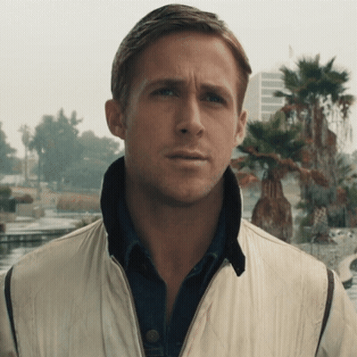 A Man Wearing A White Jacket And A Blue Shirt Looks At The Camera GIF