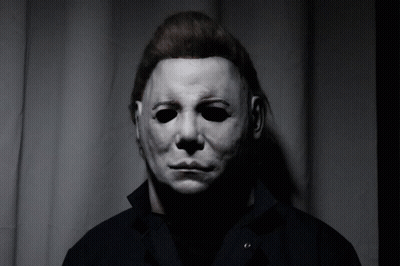 A Man Wearing A White Mask And A Black Jacket GIF