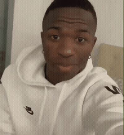 A Man Wearing A White Nike Hoodie Is Looking At The Camera GIF