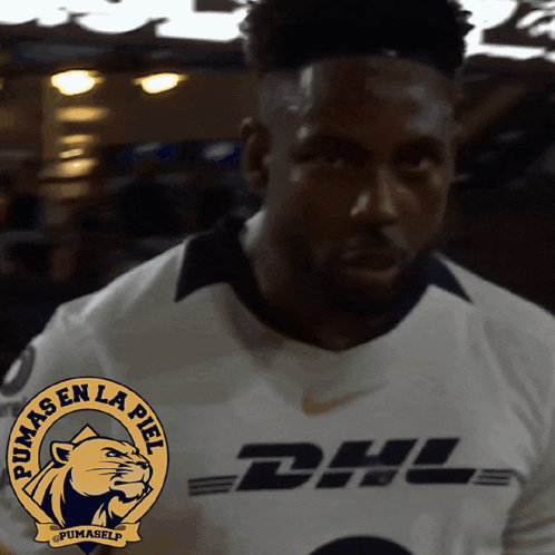 A Man Wearing A White Pumas Jersey With Dhl On The Front GIF
