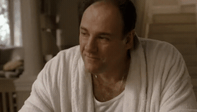 A Man Wearing A White Robe And A White Shirt Is Smiling . GIF