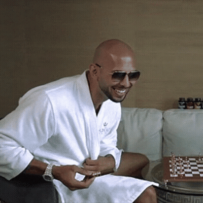 A Man Wearing A White Robe And Sunglasses Is Sitting On A Couch GIF