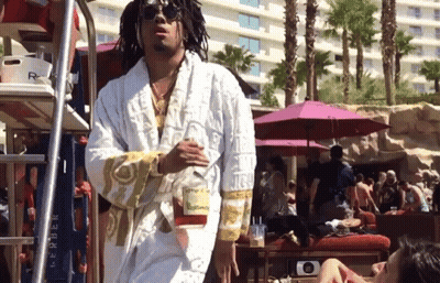 A Man Wearing A White Robe With The Word Versace On The Sleeves GIF