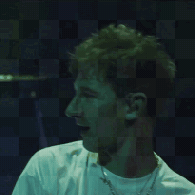 A Man Wearing A White Shirt And A Chain Around His Neck GIF