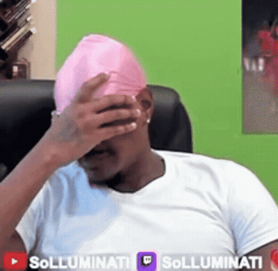 A Man Wearing A White Shirt And A Pink Hat Covering His Face GIF
