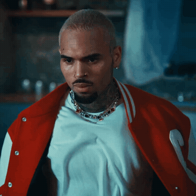 A Man Wearing A White Shirt And A Red Jacket Is Looking At The Camera GIF