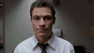 A Man Wearing A White Shirt And A Tie Looks At The Camera GIF