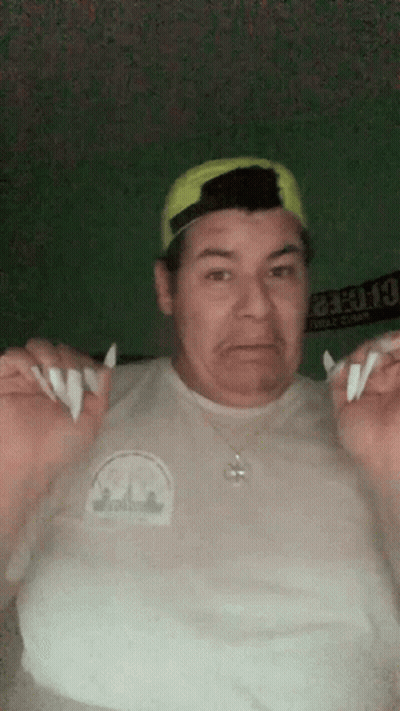 A Man Wearing A White Shirt And A Yellow Hat Is Holding Something In His Hands . GIF