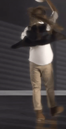 A Man Wearing A White Shirt And Khaki Pants Is Dancing GIF