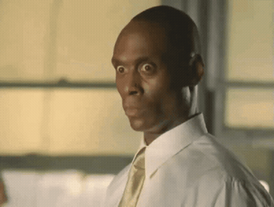 A Man Wearing A White Shirt And Tie Is Making A Funny Face . GIF