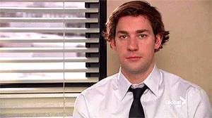 A Man Wearing A White Shirt And Tie Is Sitting In Front Of A Window . GIF