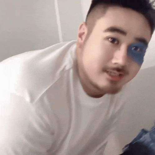 A Man Wearing A White Shirt Has A Blue Patch On His Eye GIF