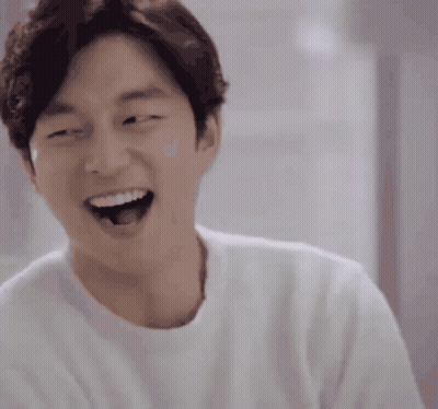 A Man Wearing A White Shirt Is Laughing With His Mouth Wide Open GIF