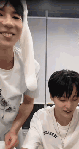 A Man Wearing A White Shirt That Says 30A2a3v Stands Next To Another Man GIF