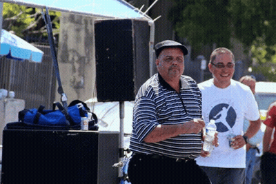 A Man Wearing A White Shirt With A Bird On It Holds A Bottle Of Water GIF