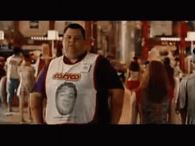 A Man Wearing A White Shirt With A Picture Of A Man On It Is Standing In A Crowded Room . GIF