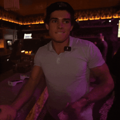 A Man Wearing A White Shirt With A Purple Light Behind Him That Says ' A ' On It GIF