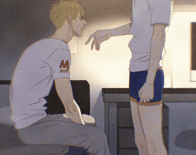 A Man Wearing A White Shirt With The Letter M On It Talks To Another Man GIF