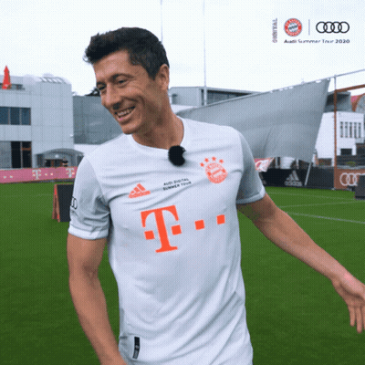 A Man Wearing A White Shirt With The Letter T On The Front GIF