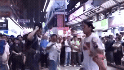 A Man Wearing A White Shirt With The Word Supreme On It Stands In Front Of A Crowd GIF