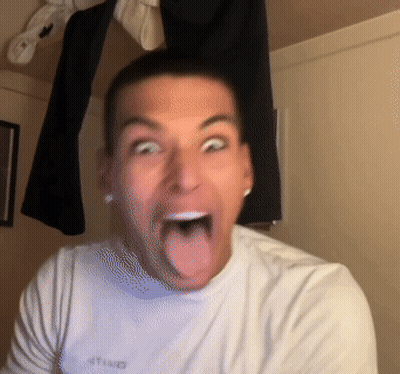 A Man Wearing A White Shirt With The Word United On It Sticks Out His Tongue GIF
