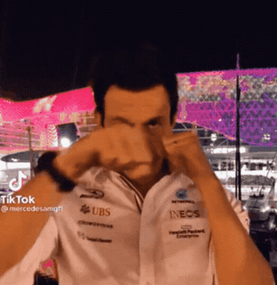 A Man Wearing A White Shirt With Ubs And Inecs Logos On It GIF