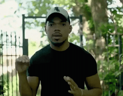 A Man Wearing A White Sox Hat Is Standing In Front Of A Gate GIF